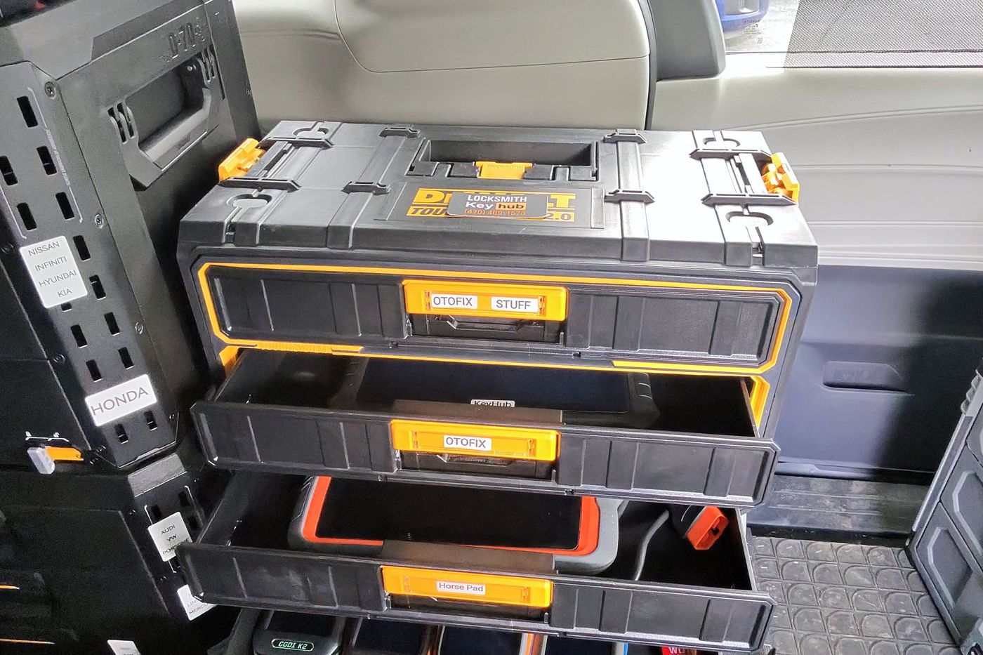 Drawers of key programmers labelled by vehicle make inside the KeyHub van